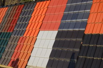 Dachziegel in Orange, Dunkelgrau, Hellgrau und Grün nebeneinander ausgestellt
