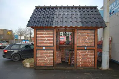 Kleines Ausstellungshaus mit Klinkerwänden und dunklem Ziegeldach
