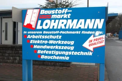 Schild vor dem Baustoff-Fachmarkt: Arbeitsschutz, Elektro-Werkzeug, Handwerkszeug, Befestigungstechnik, Bauchemie