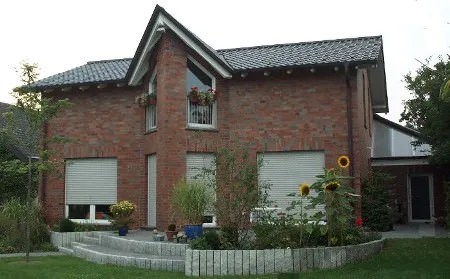 Rotes Backsteinhaus mit Gauben und Garten